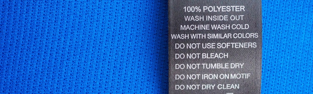 Plain blue fabric showing a 100% polyester label and washing instructions